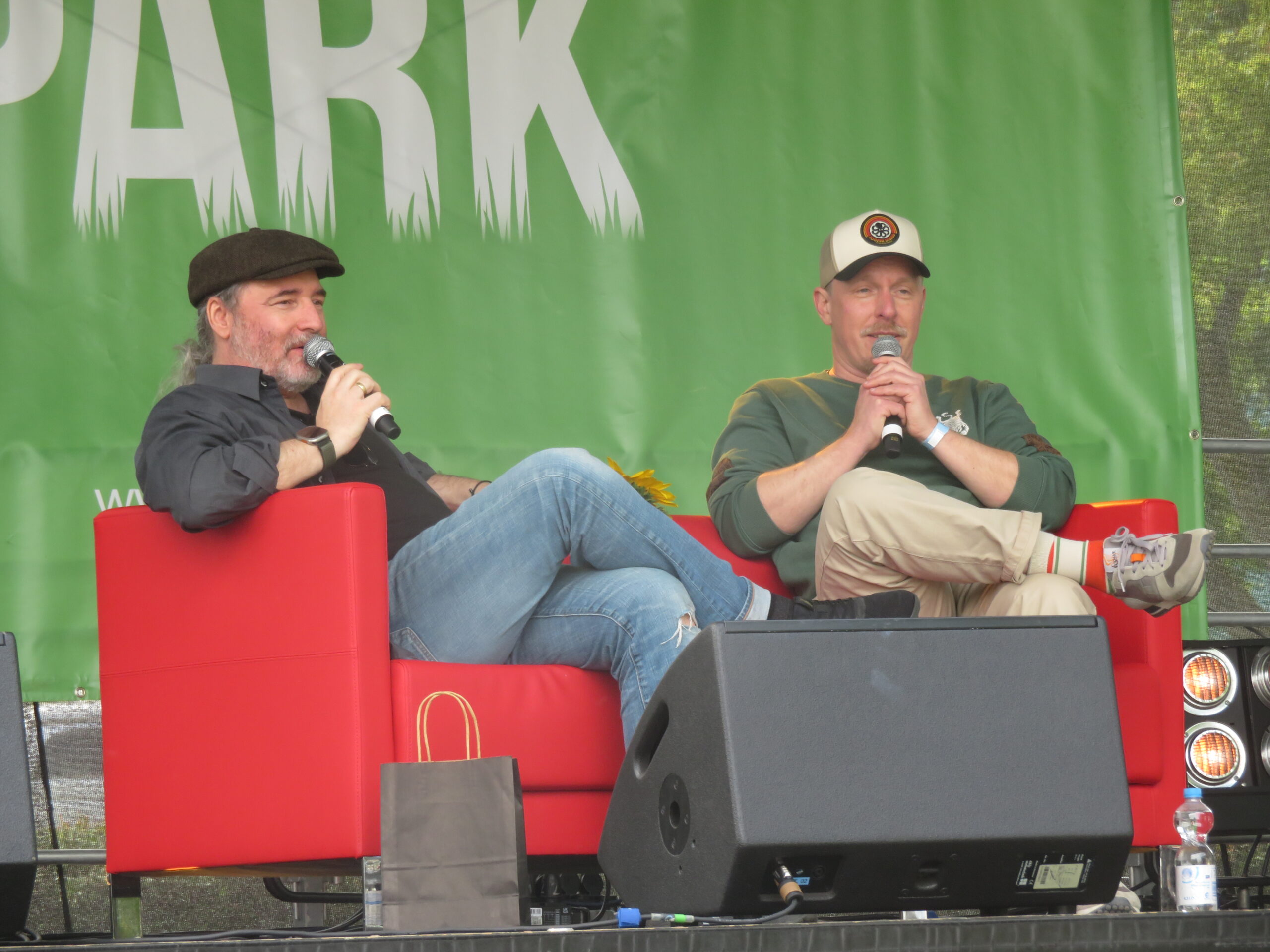 Tommy Krappweis und Normen Cöster sitzen mit Mikrofonen auf der Bühne und beantworten die Fragen der Fans.