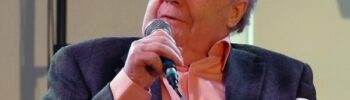 Josef Göhlen spricht während des bumm-Events im Oktober 2015 bei einem Vortrag in ein Mikrofon. Er halt in der rechten Hand ein Mikrofon, in der linken einen Notiz-Zettel.